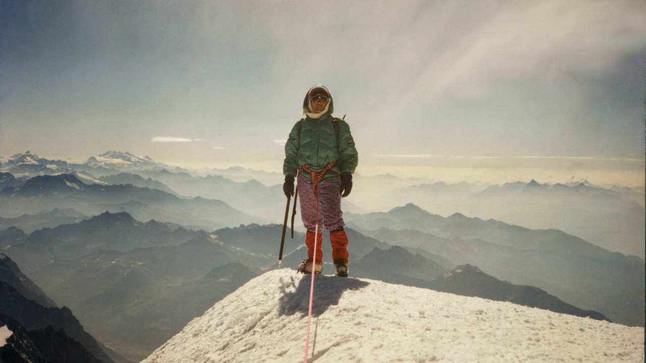 a woman standing on top of a mountain
