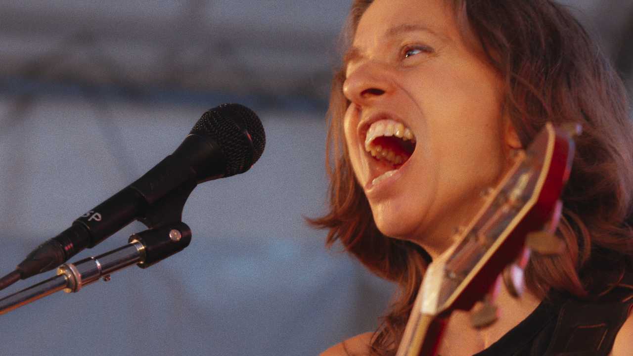 Ani DiFranco singing into a microphone