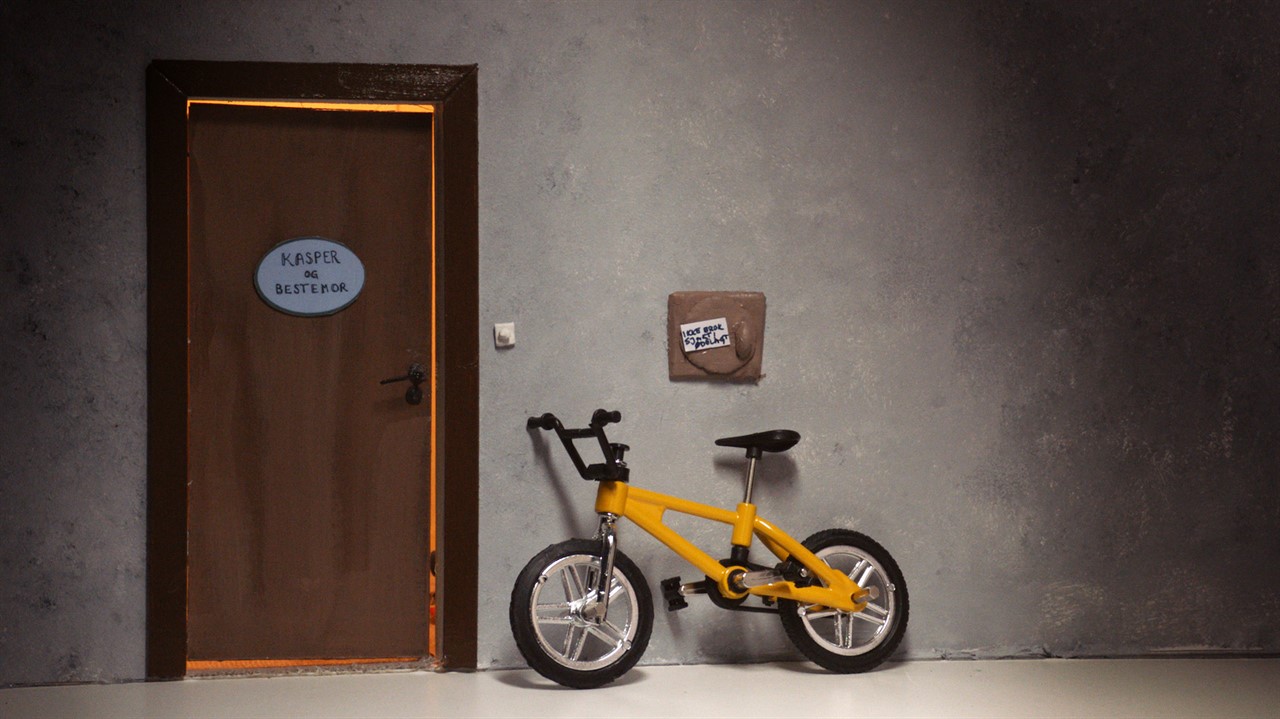 Toy bike beside a doll house door