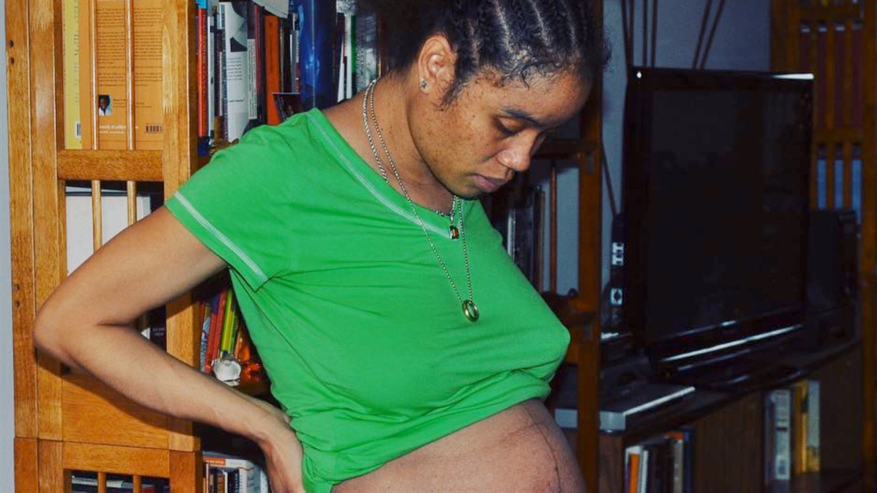 Pregnant woman looks at her belly