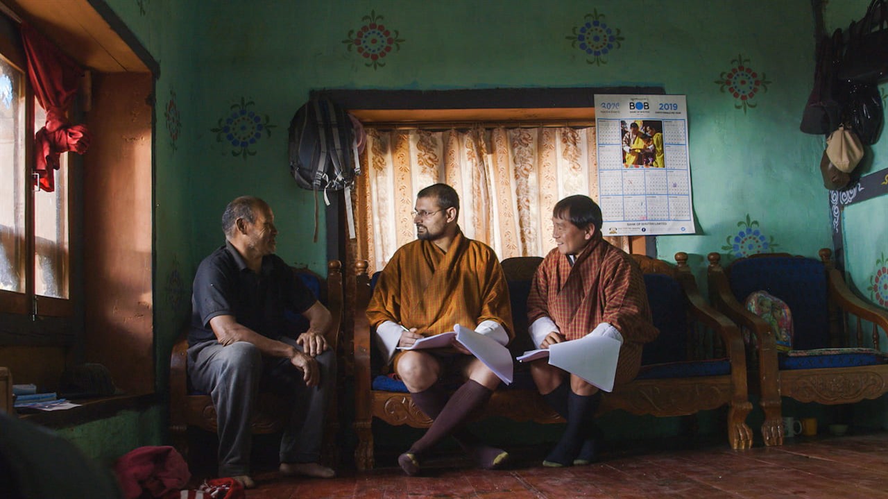 Three men, sitting in a living room, chatting