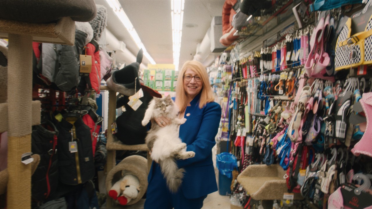 Woman holding a cat in the aisle of a pet store