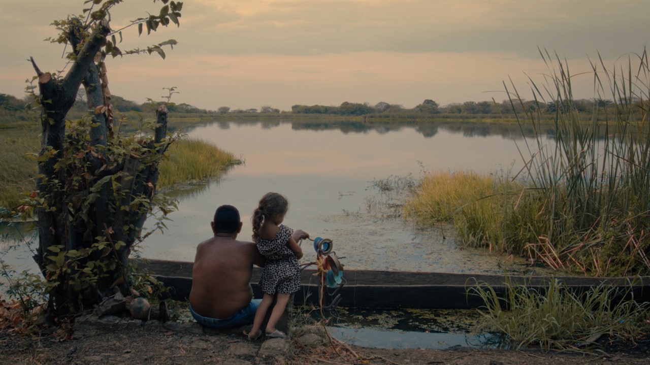 A man and child looking at a small lake