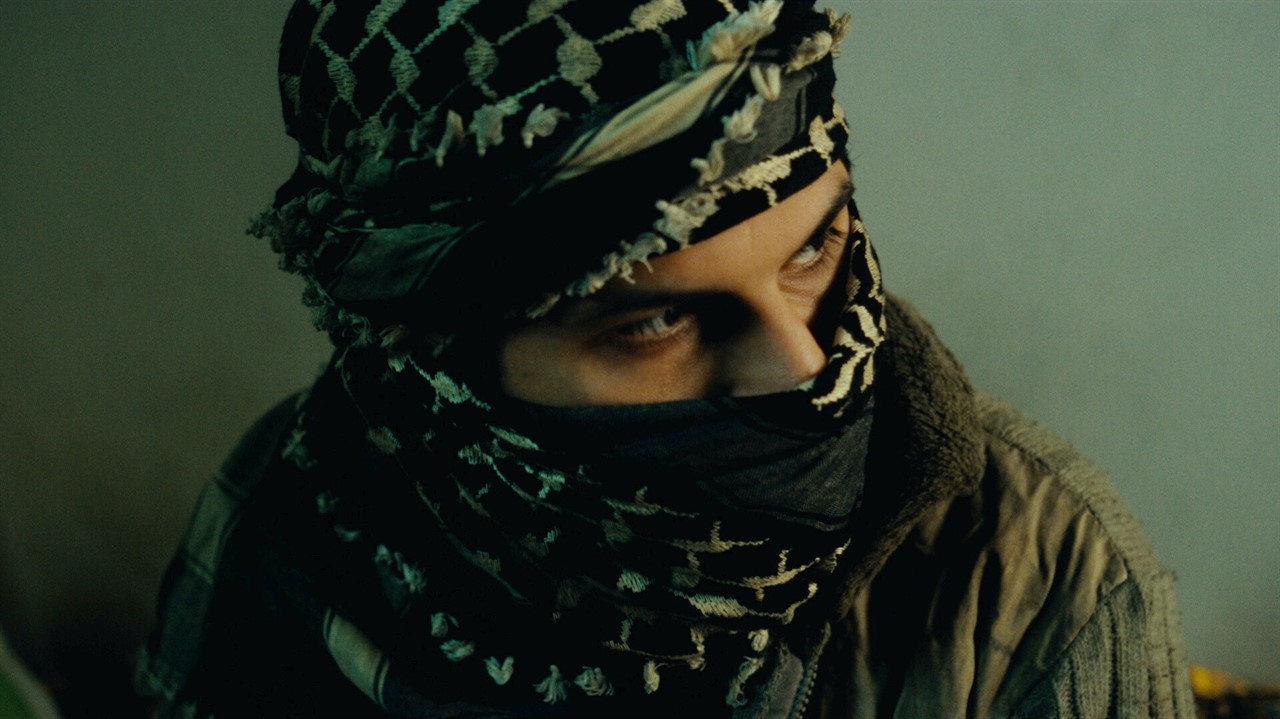 Person wearing a scarf covering his head and mouth