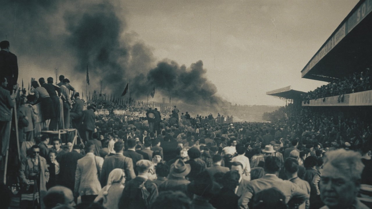 Large crowd of people watch a large plume of smoke