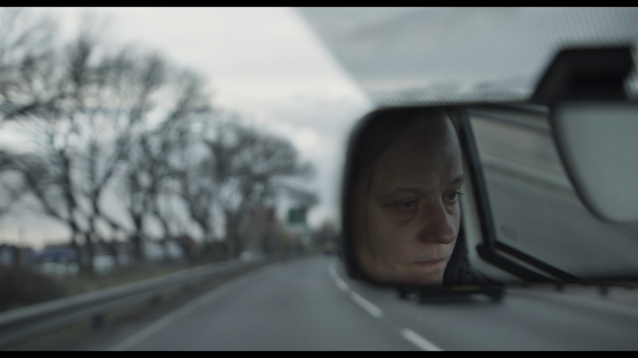 Woman's face in a car rearview mirror