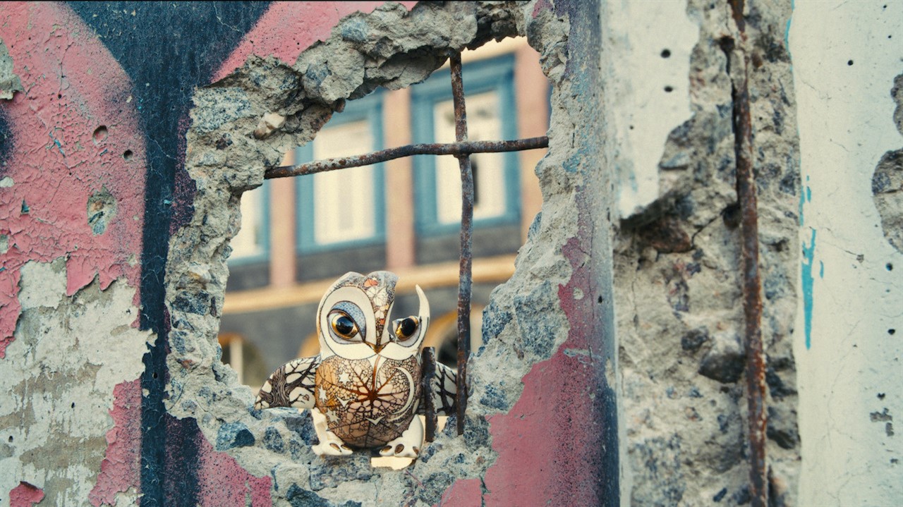 Porcelain owl sitting in a hole in a concrete wall