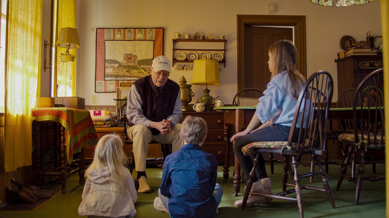 An old man speaks to listening children