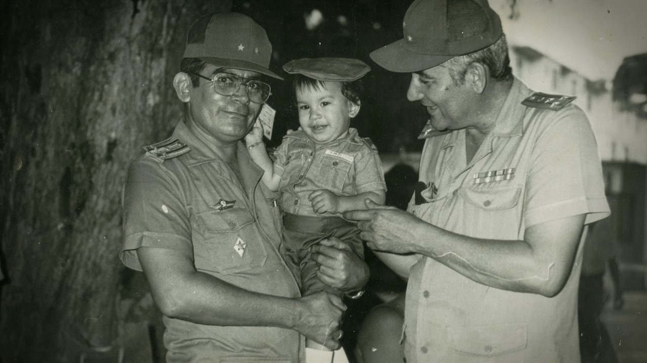 Two men in uniform holding a child