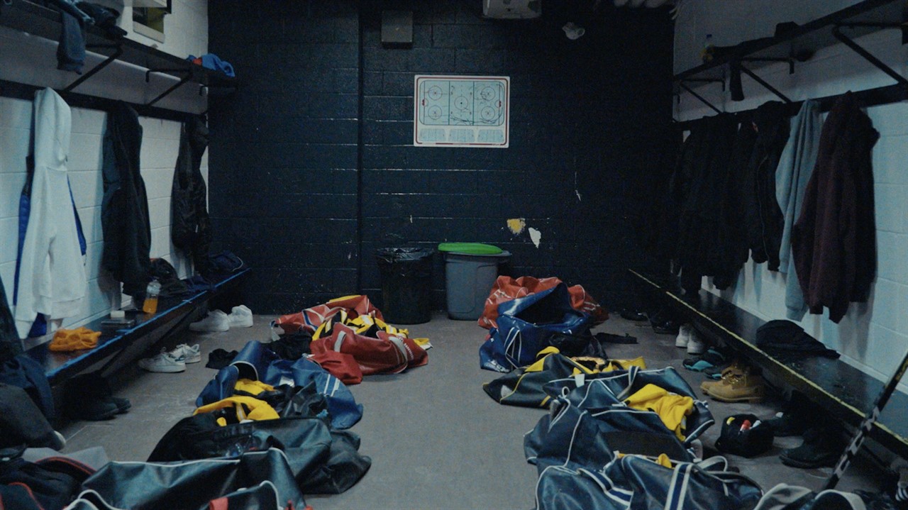 Hockey locker room with open hockey bags on floor