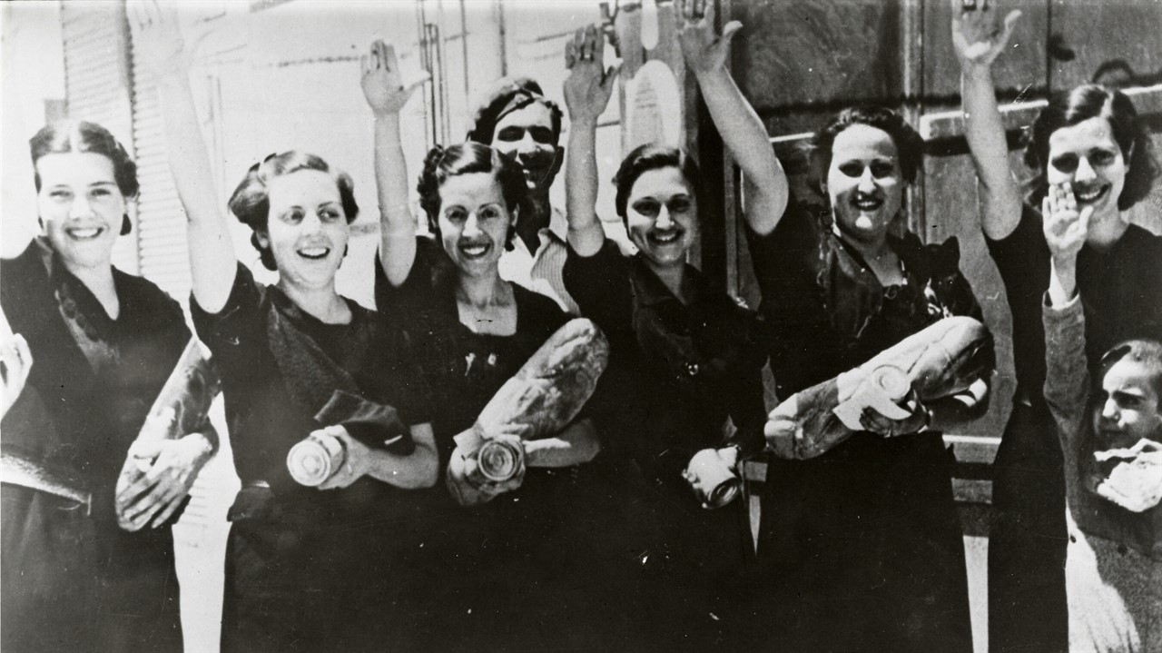 Women holding bread with right hand raised