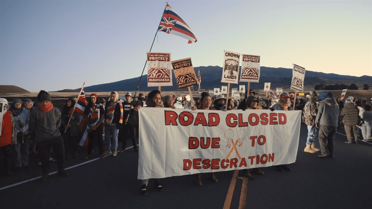 Protesters sign: Road Closed due to Desecration