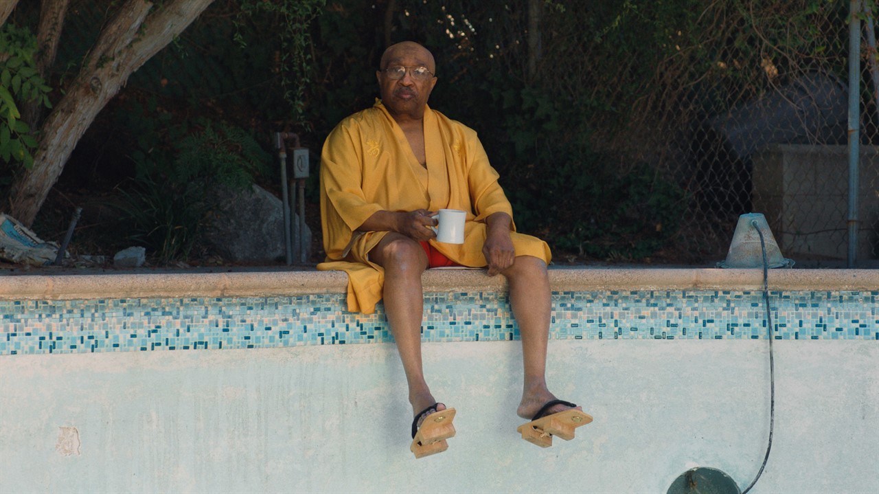 Swamp Dogg sitting at the edge of an empty pool