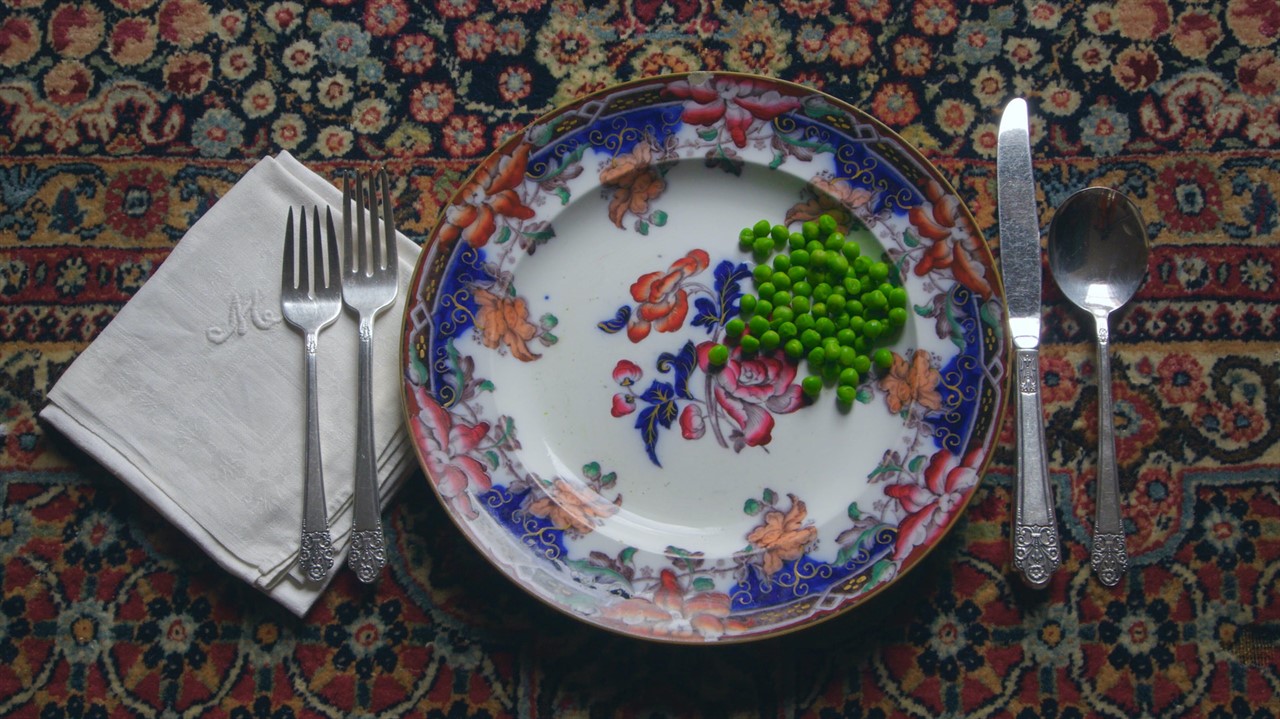 Place setting with only peas on a flowery plate