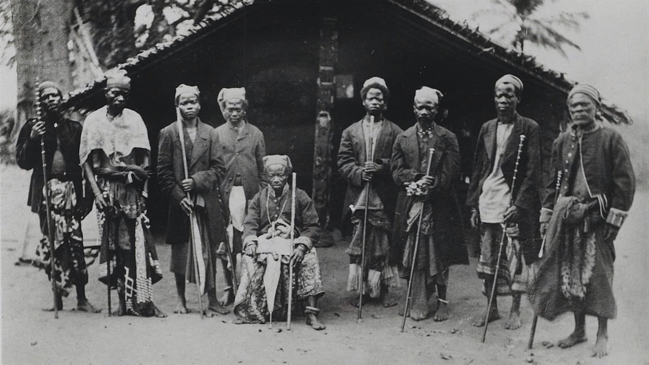 Old photo of a group of men outside a hut