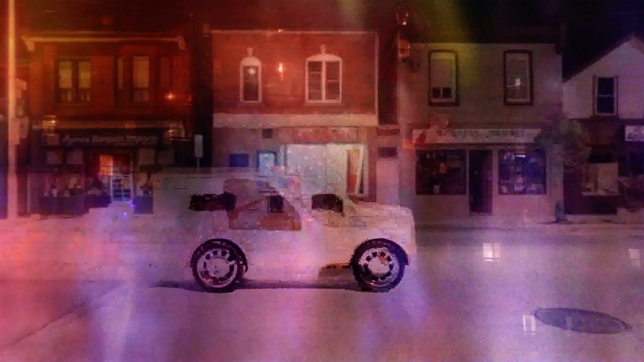 Pixilated image of a van driving down a shop-lined