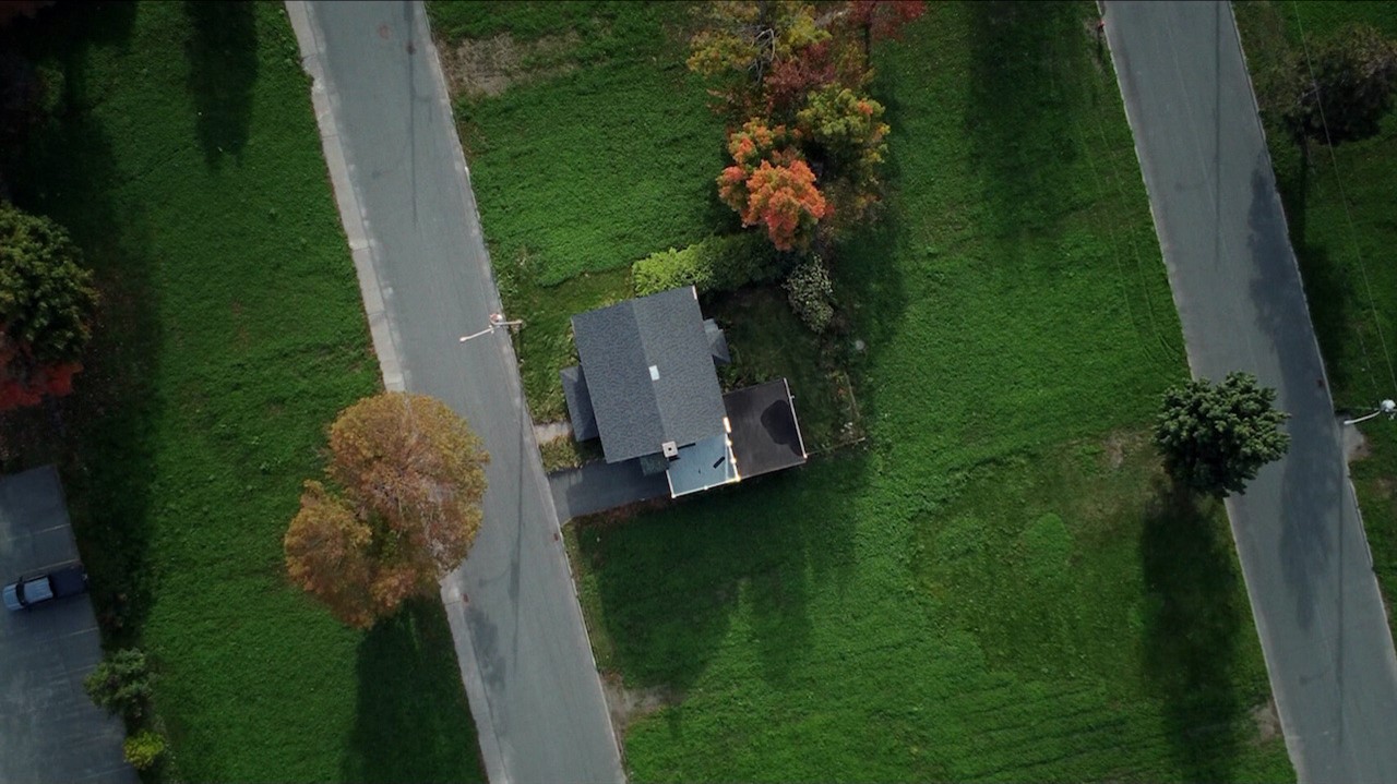 Aerial view of a small house an large lawn