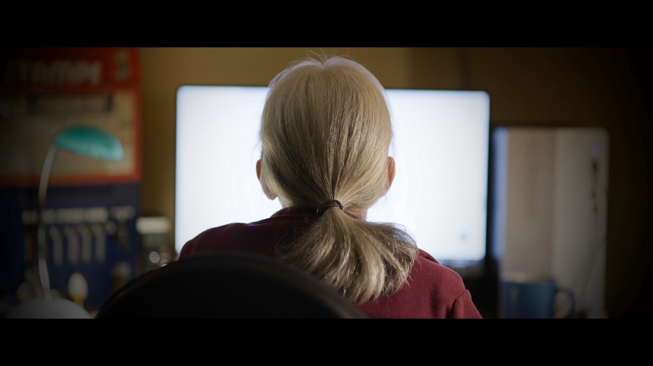 Back of a person's head looking at a computer scre