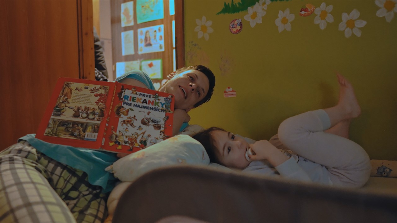 Woman reading to a child in bed