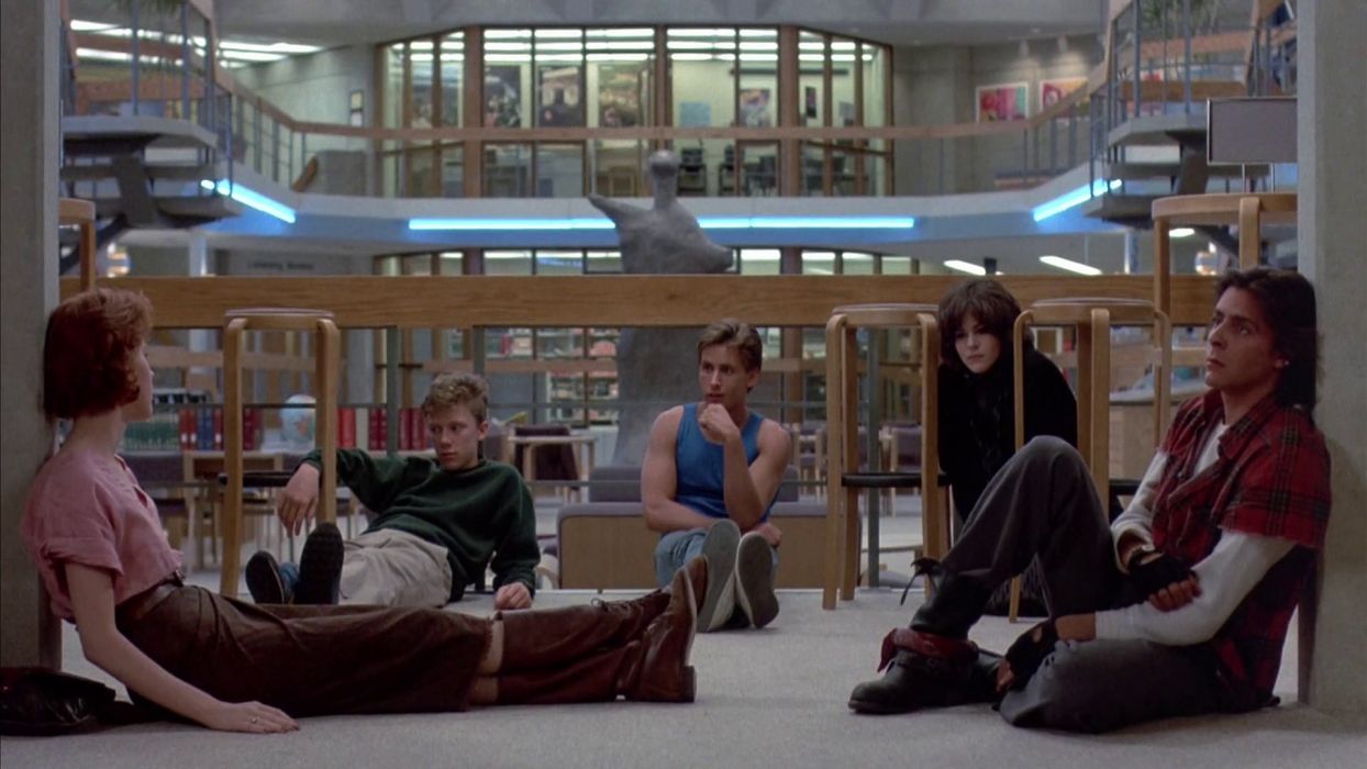 five teens sitting together in a library