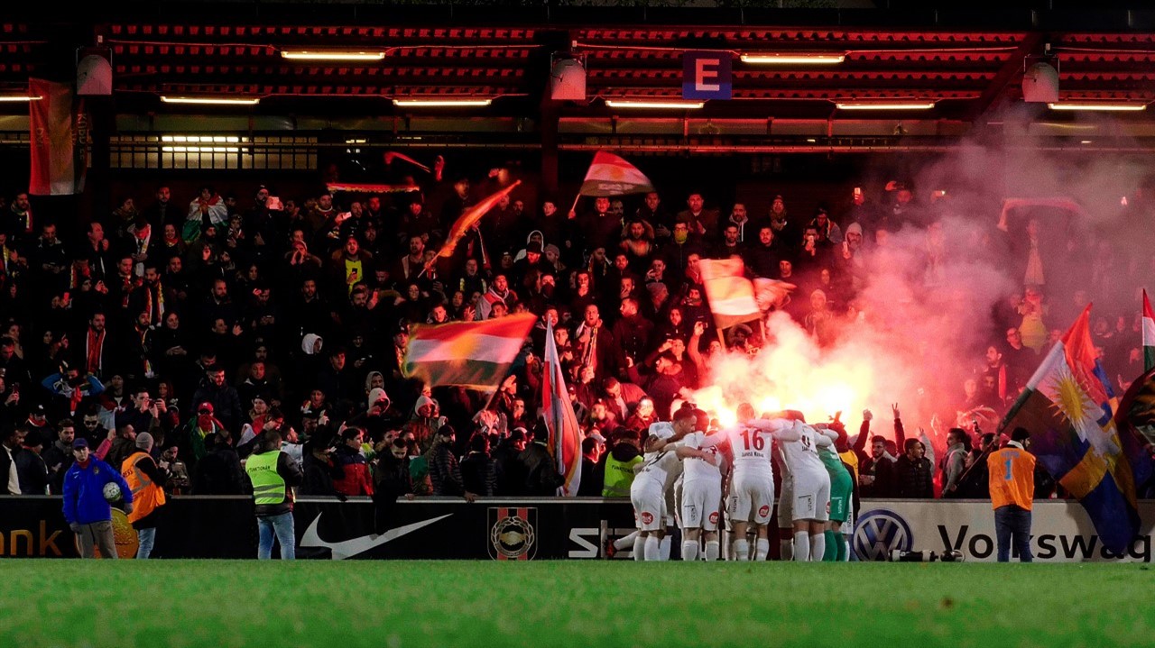 Cheering soccer fans with flares in the stands