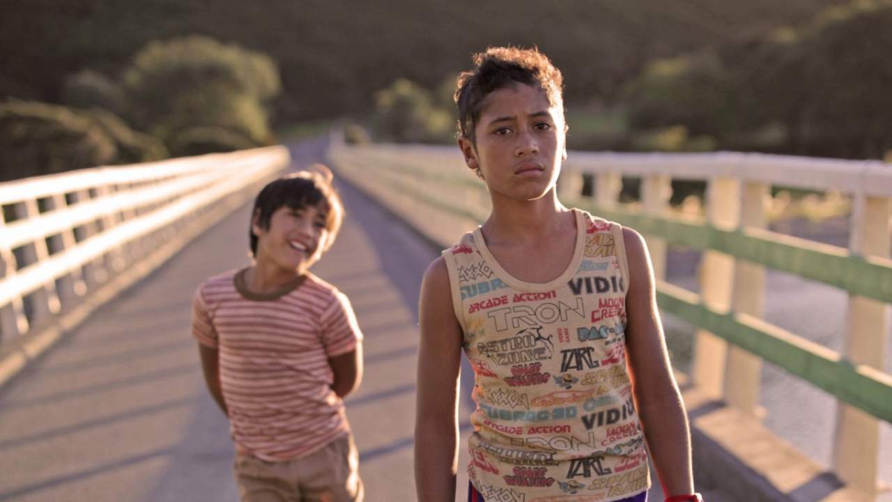 two children walking along a bridge