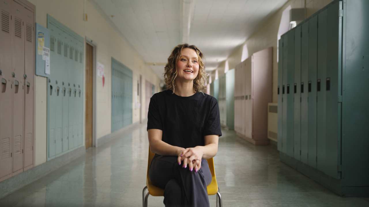 Jordan Todosey sitting on a chair in a school hall