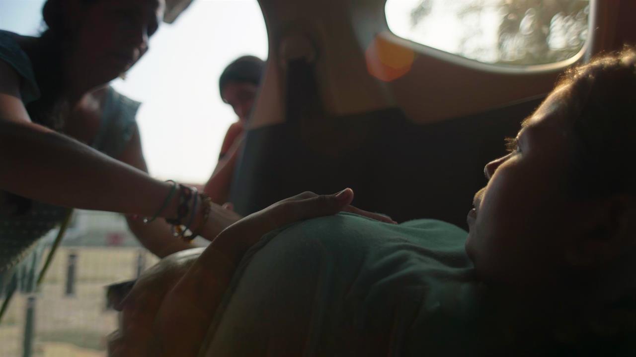 A pregnant woman being examined by a midwife