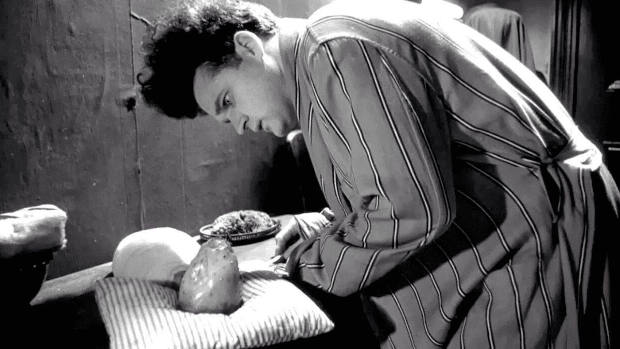 a man in stripes looking at an object on a pillow