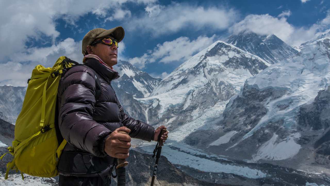a man with a backpack hiking up a mountain