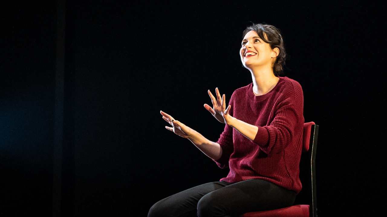 a woman sitting on a chair and looking up smiling