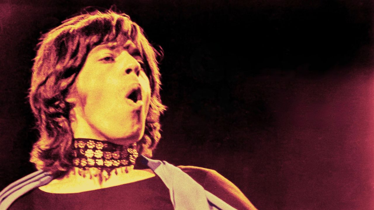 Mick Jagger singing and wearing a choker