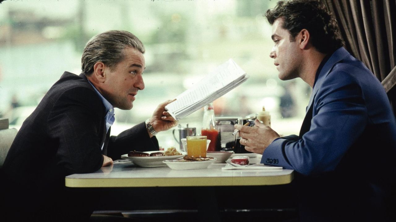 Robert De Niro & Ray Liotta talking at a table