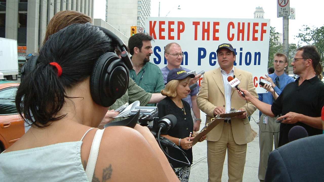 a man with a baseball cap being interviewed