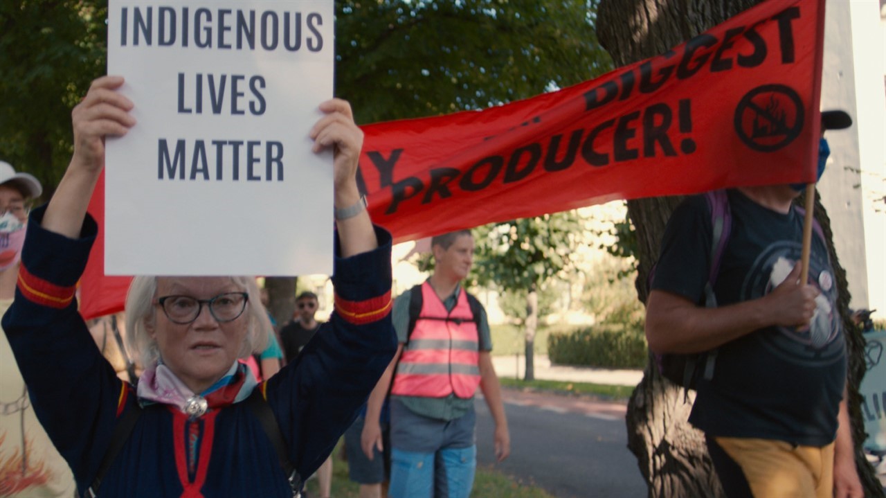 Woman with glasses holding up a sign