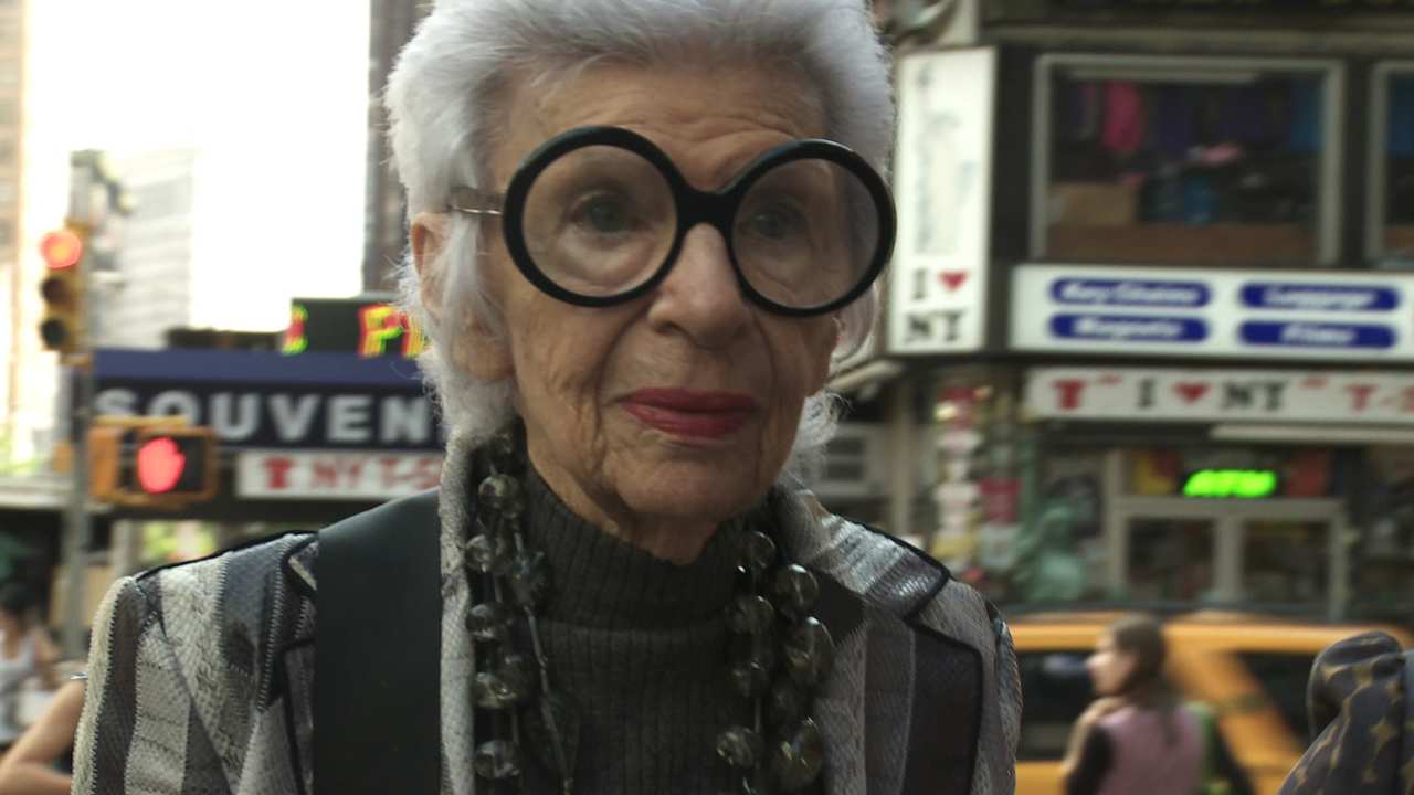 a woman with large round glasses on the street
