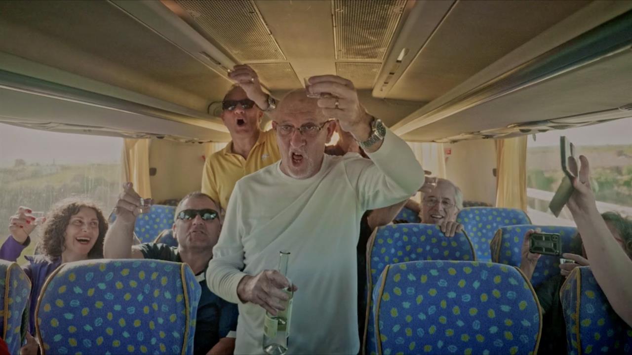 People on bus toasting with grappa
