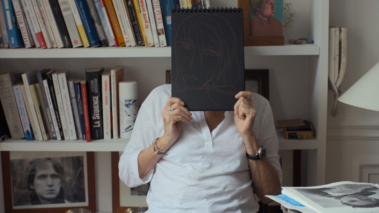 Woman holds illustration in front of her face