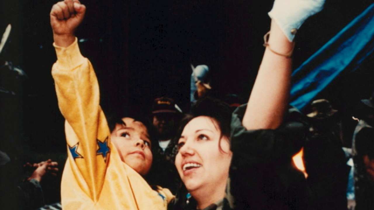 a woman and child with their fists in the air