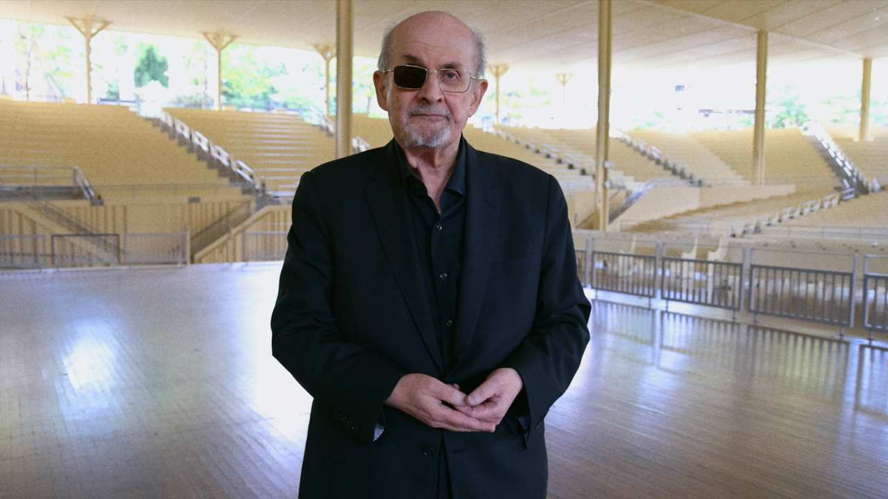 Salman Rushdie on stage at a venue