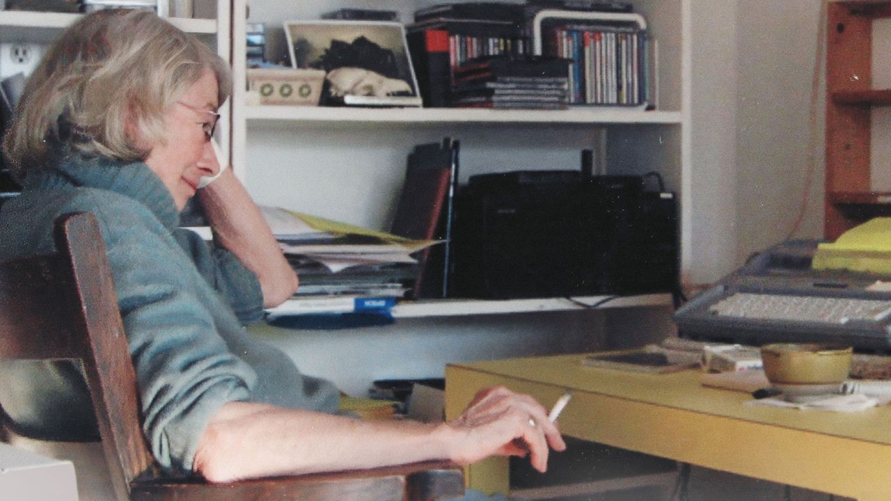 a woman with glasses sitting at a desk