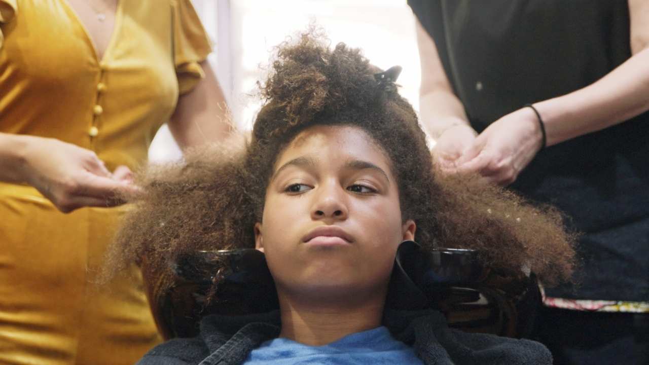 a girl getting her hair styled