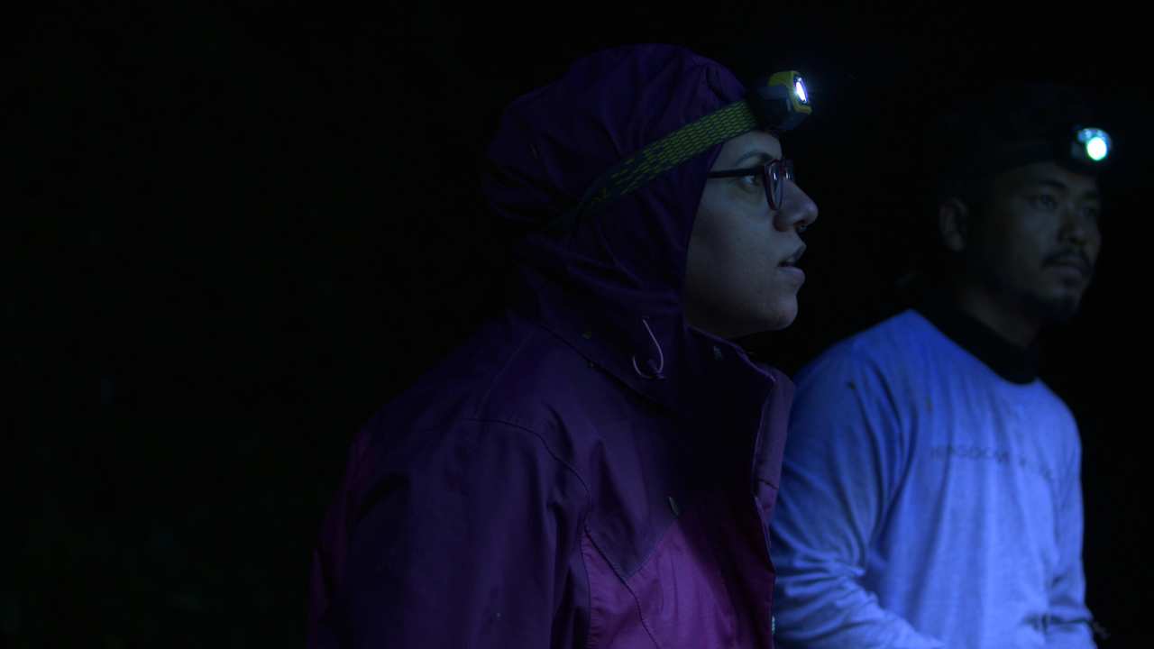 two people with lights on their heads in the dark