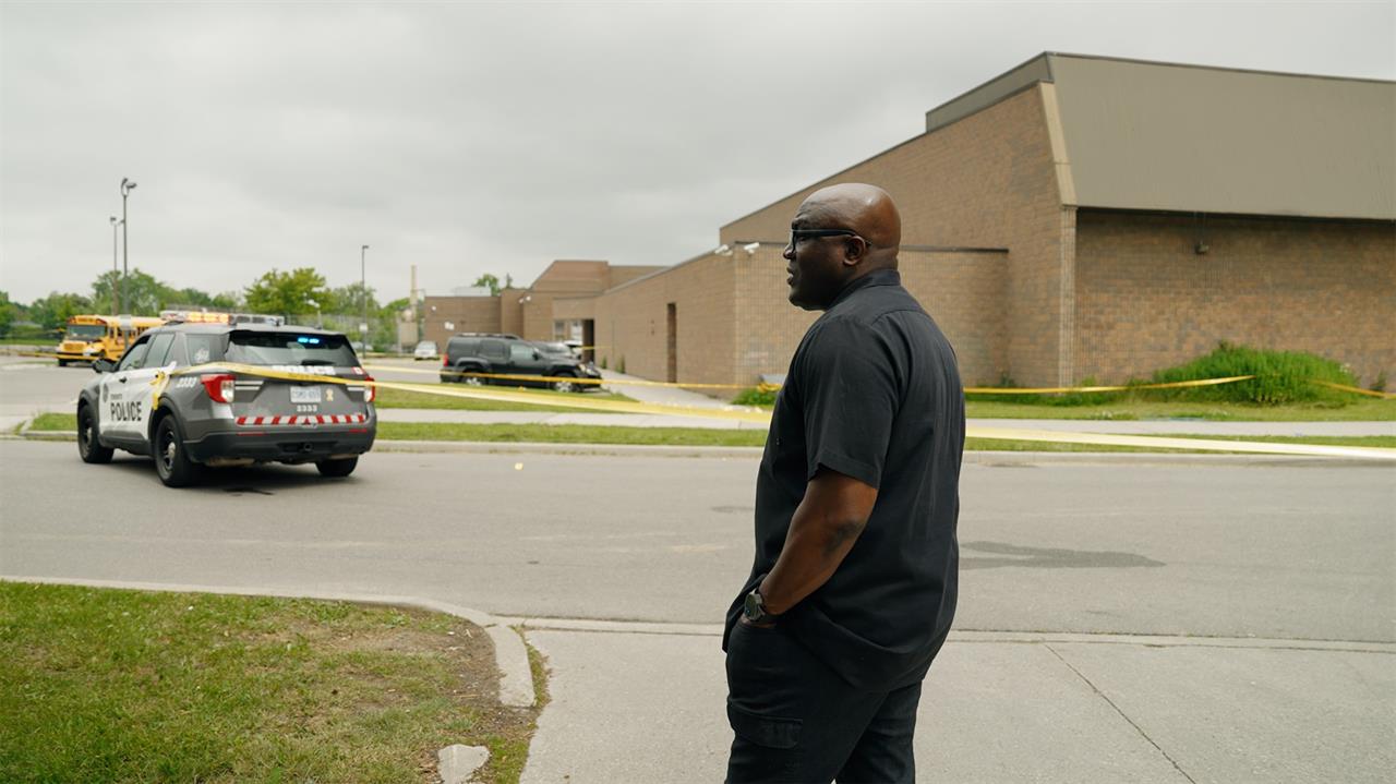 Man in front of police car and tape