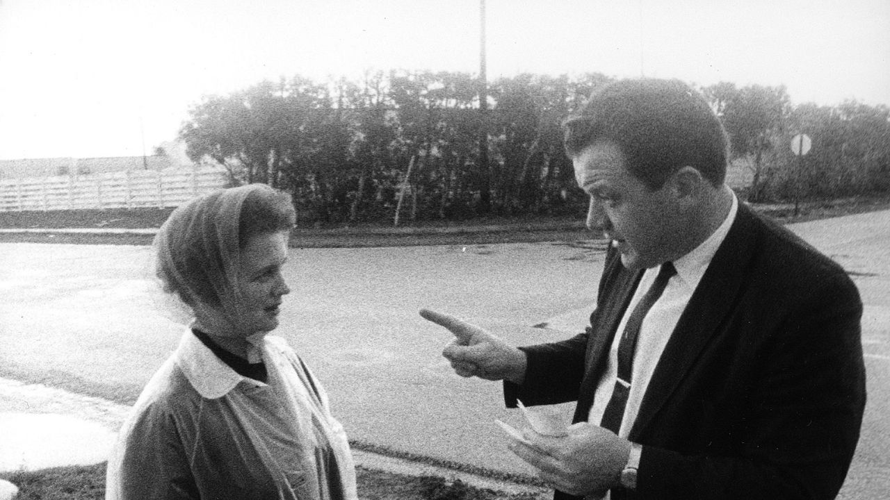 a salesman talking to a woman with a headscarf