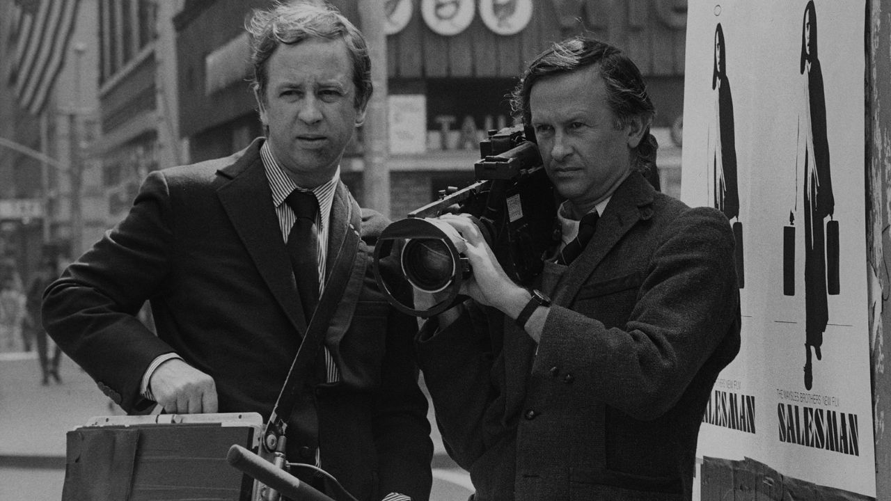two men in suits with a camera
