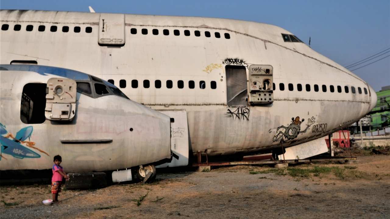a child standing in front of two old planes