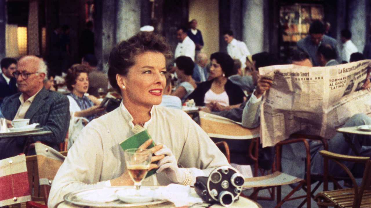 Katherine Hepburn sitting at a busy cafe