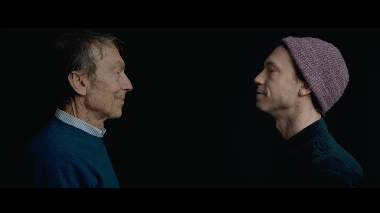 A young man and old man looking at each other