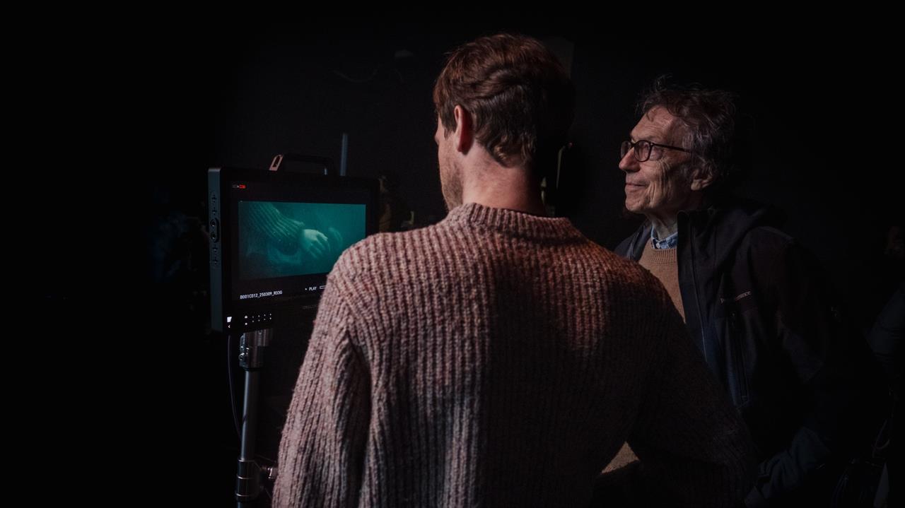Two men look at a film monitor